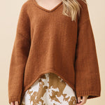 Woman wearing a brown sweater with a beige background