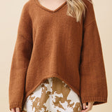 Woman wearing a brown sweater with a beige background