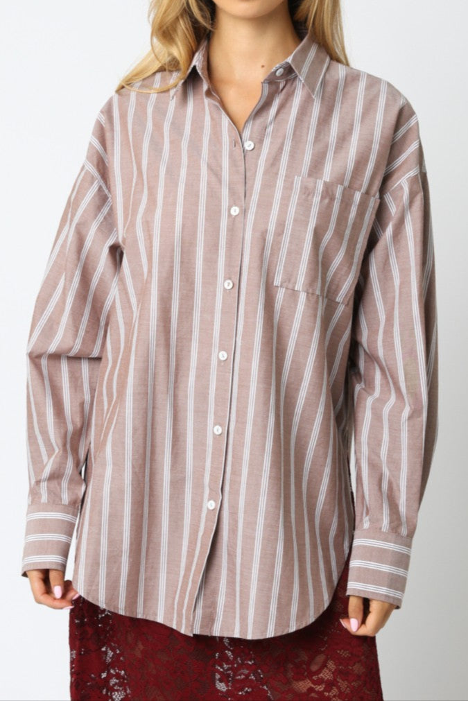 Woman wearing a striped shirt against a plain background