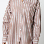 Woman wearing a striped shirt against a plain background