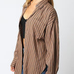 Woman wearing a brown pinstripe shirt against a white background