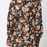 Woman wearing a floral dress with long sleeves on a white background