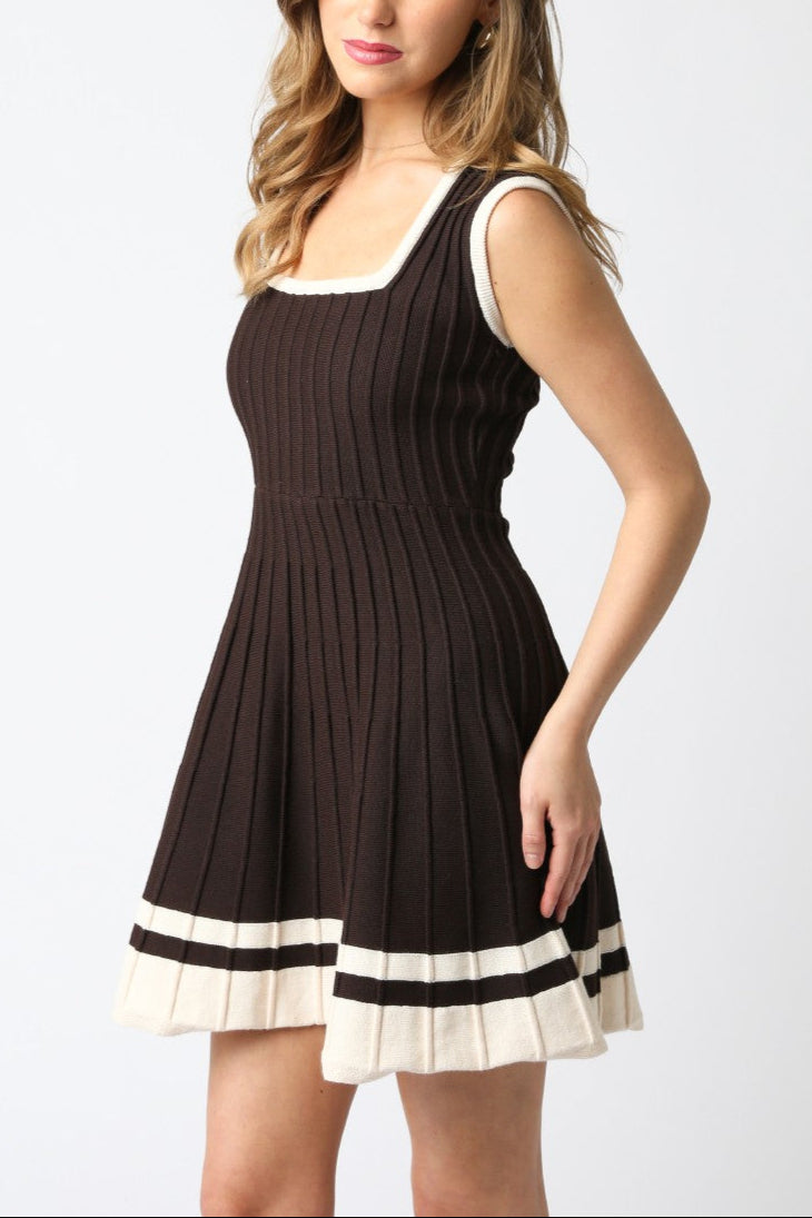 Woman wearing a brown dress with white trim on a white background