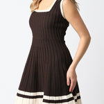 Woman wearing a brown dress with white trim on a white background