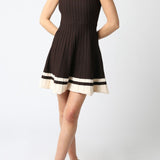 Woman wearing a black dress with white trim on a white background