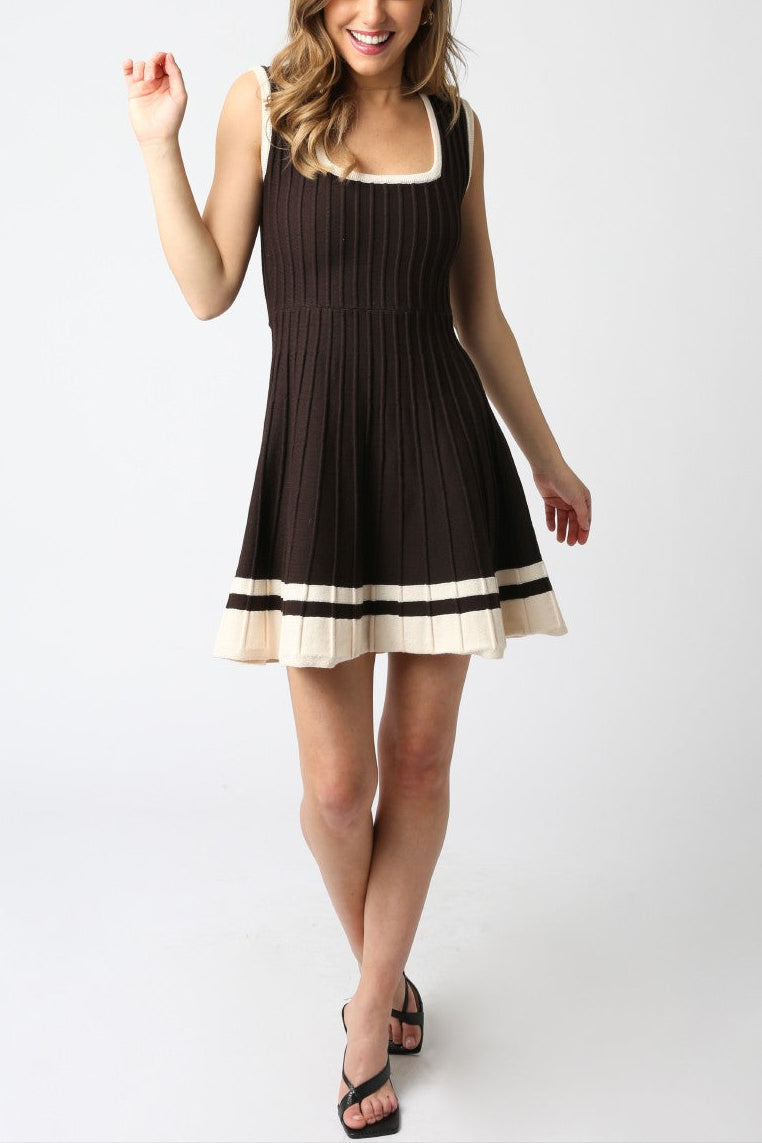 Woman wearing a black dress with white trim on a white background