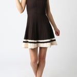 Woman wearing a black dress with white trim on a white background