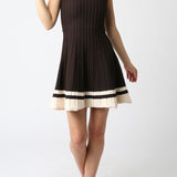 Woman wearing a black dress with white trim on a white background