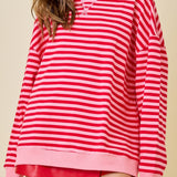 Woman wearing a red and white striped sweater with a beige background