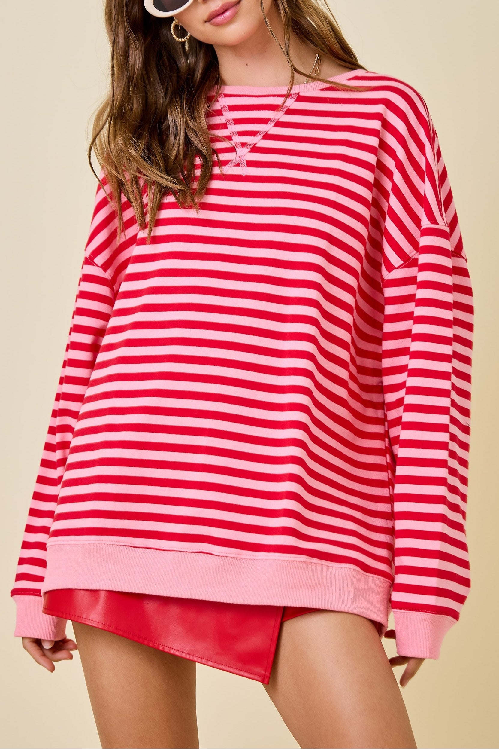 Woman wearing a red and white striped sweater with a beige background