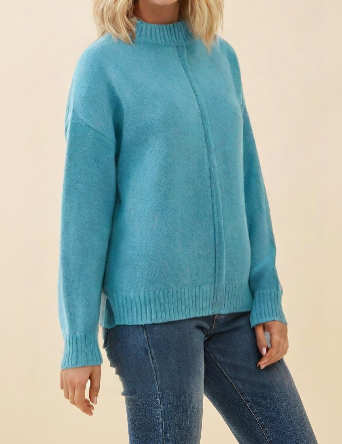 Woman wearing a blue sweater against a beige background