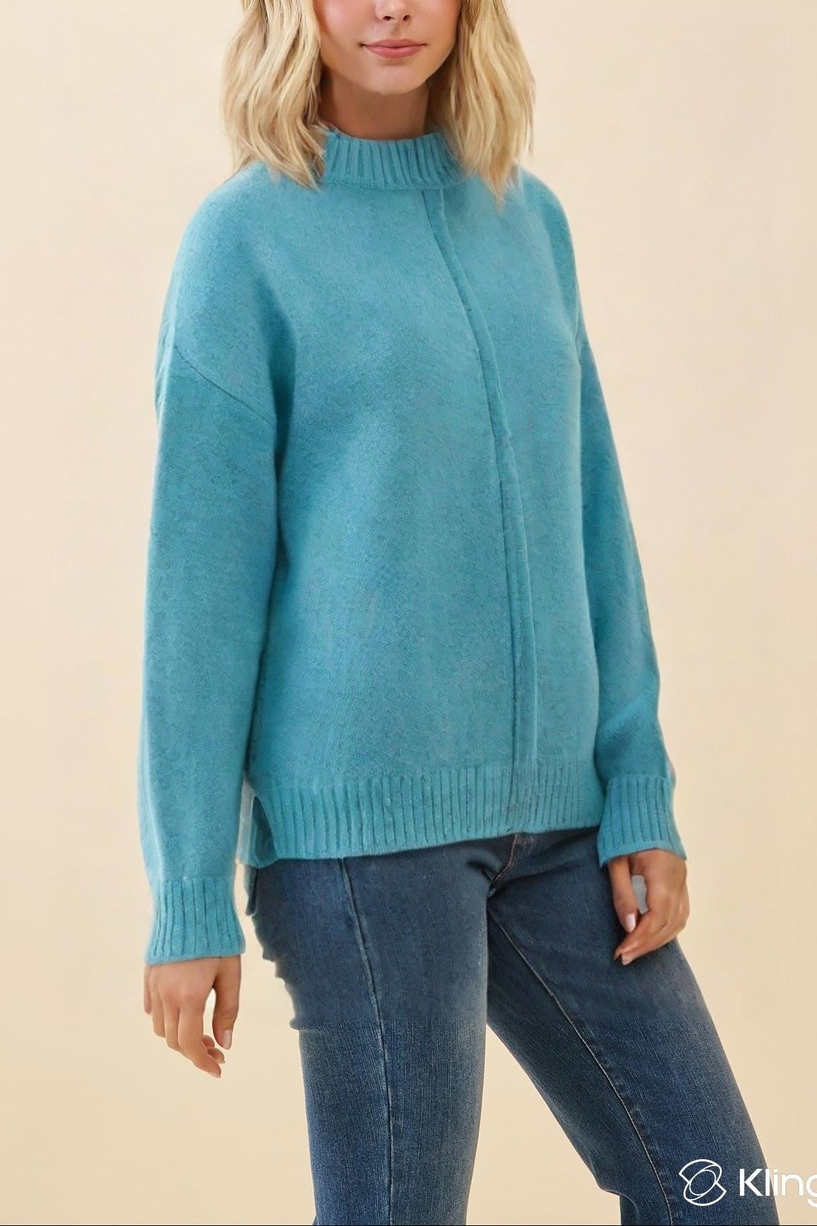 Woman wearing a blue sweater against a beige background