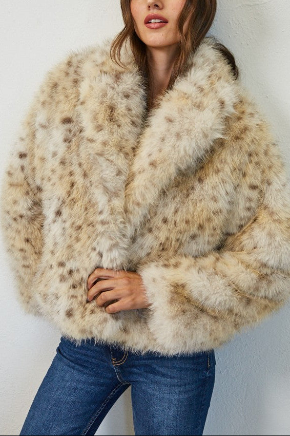 Woman wearing a fluffy beige coat against a white background
