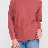 Woman wearing a red sweater and blue jeans on a white background