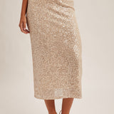 Gold sequin skirt worn by a person on a plain background