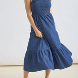 Woman wearing a blue dress standing against a white background