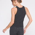 Woman wearing a black sleeveless top and pants on a white background