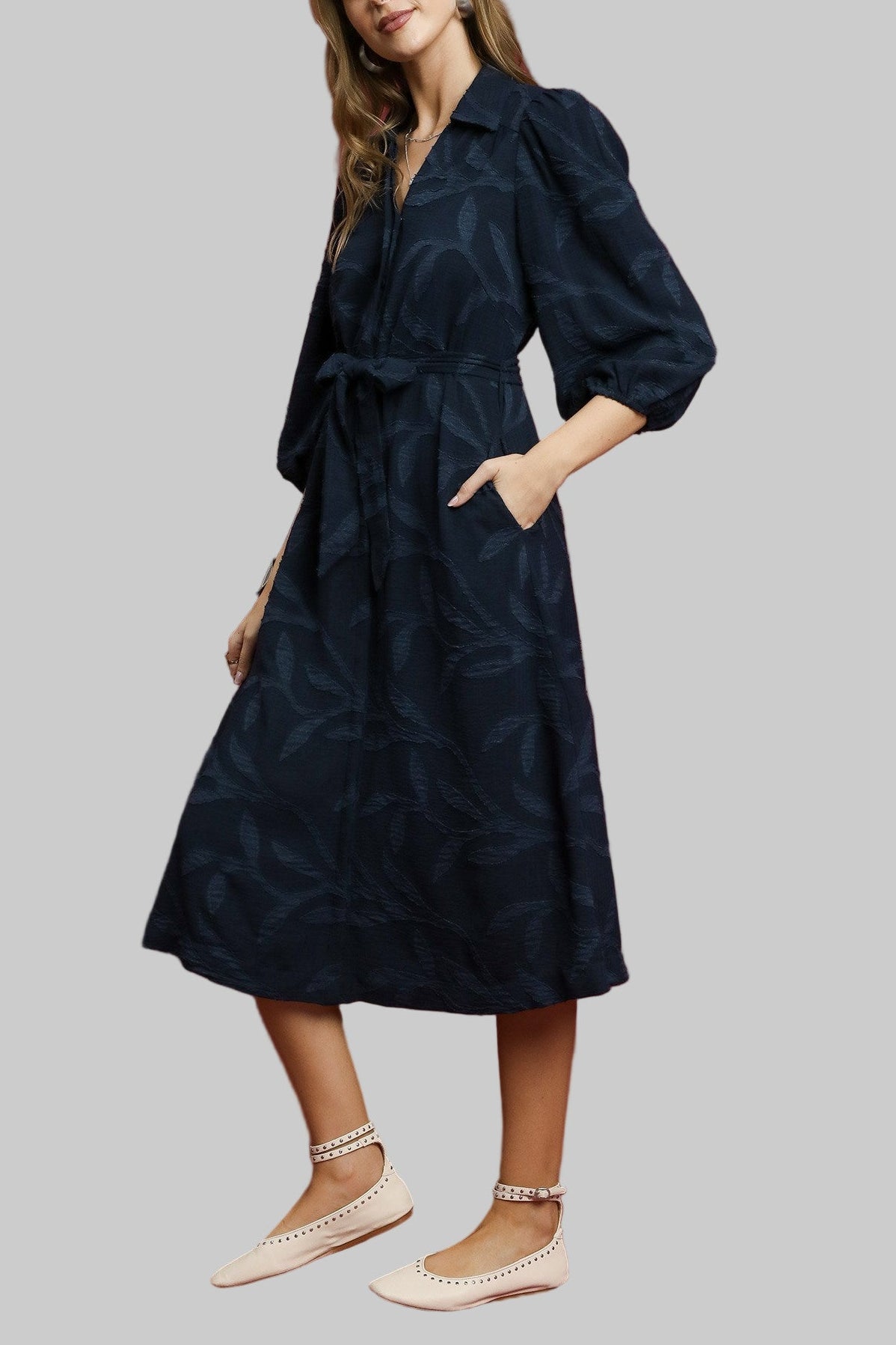 Woman wearing a navy dress against a red background