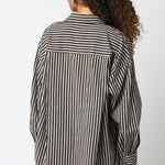 Person wearing a black and white striped shirt against a white background