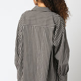 Person wearing a black and white striped shirt against a white background