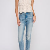 Woman wearing a white sleeveless top and blue jeans on a light gray background