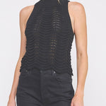 Woman wearing a black sleeveless top with a textured design on a white background