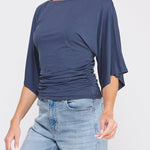 Woman wearing a blue top and jeans on a white background