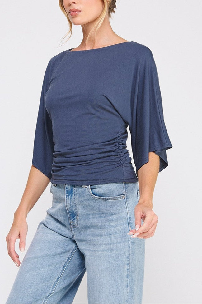 Woman wearing a blue top and jeans on a white background