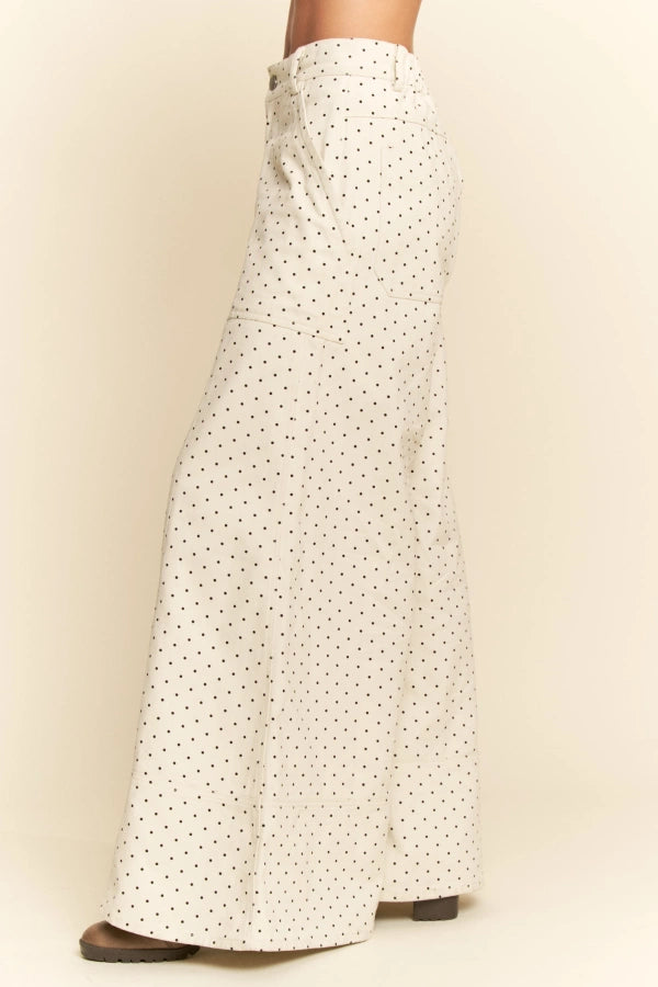 White pants with a subtle pattern worn by a person on a beige background