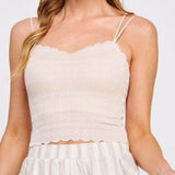 Woman wearing a beige sleeveless top and shorts on a white background