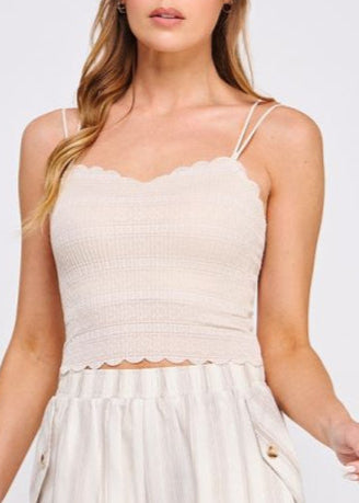 Woman wearing a beige sleeveless top and shorts on a white background