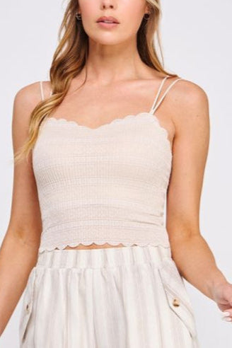 Woman wearing a beige sleeveless top and shorts on a white background