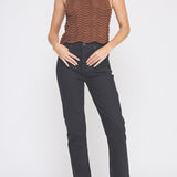 Woman wearing a brown ribbed top and black pants on a white background