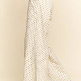 White pants with black polka dots on a beige background
