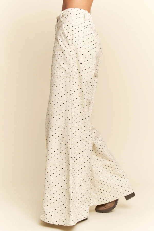 White pants with black polka dots on a beige background