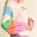 Person wearing a colorful sweater with a neutral background