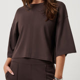 Woman wearing a brown blouse and pants on a white background