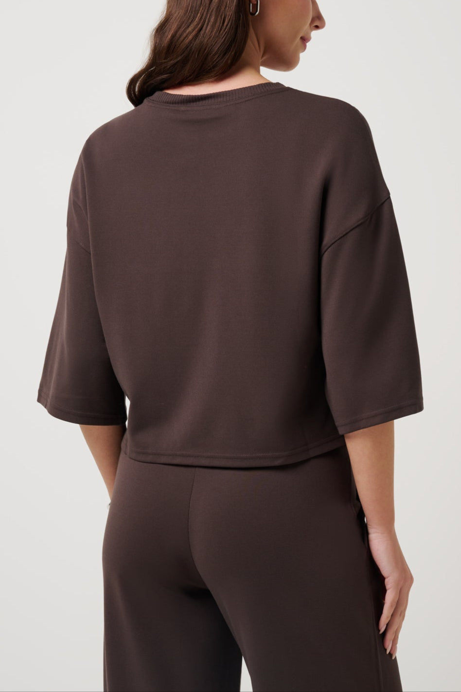 Woman wearing a brown outfit on a white background
