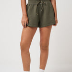 Person wearing olive green shorts on a white background