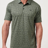 Man wearing a green patterned polo shirt against a white background
