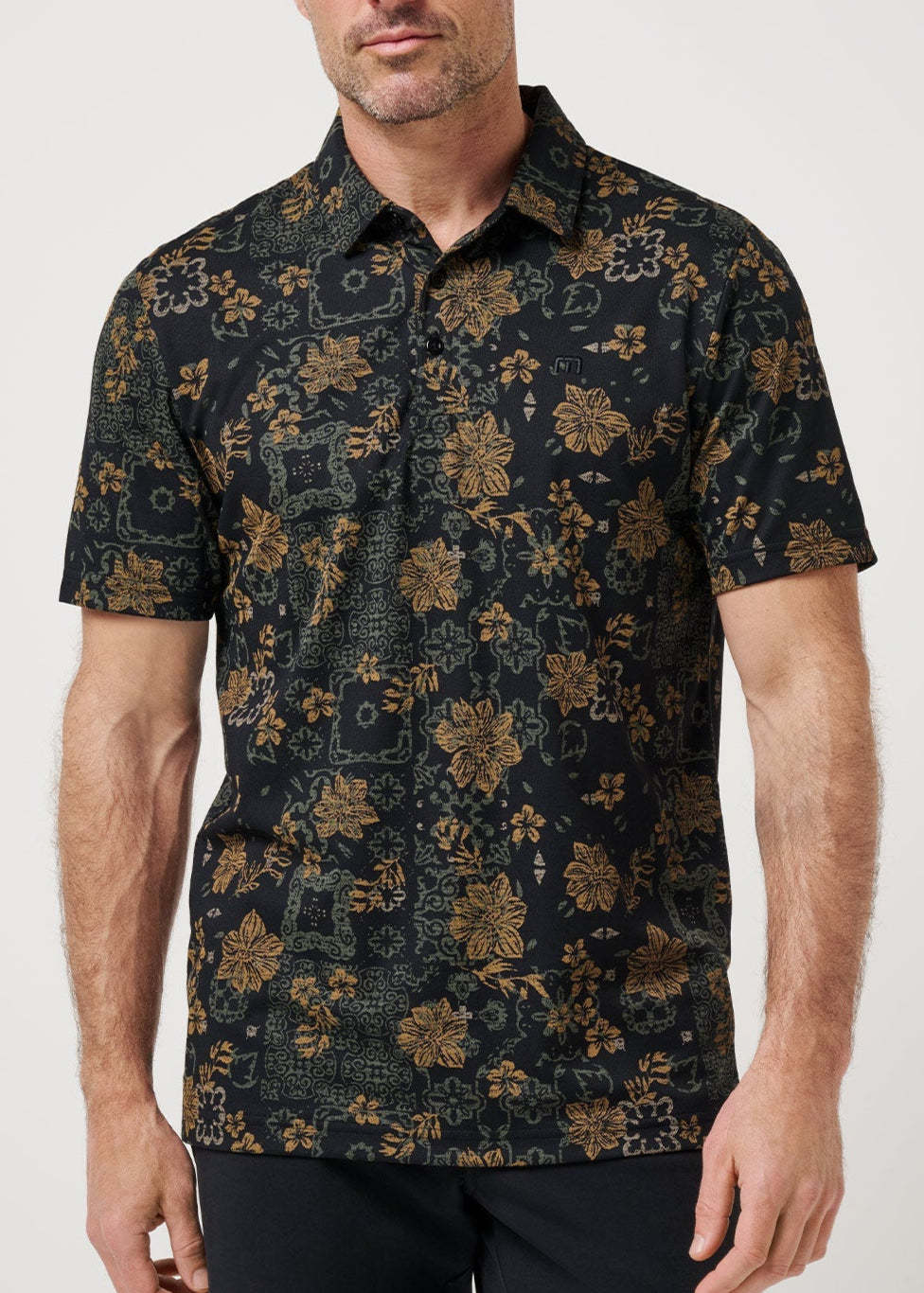 Man wearing a black floral patterned shirt against a white background