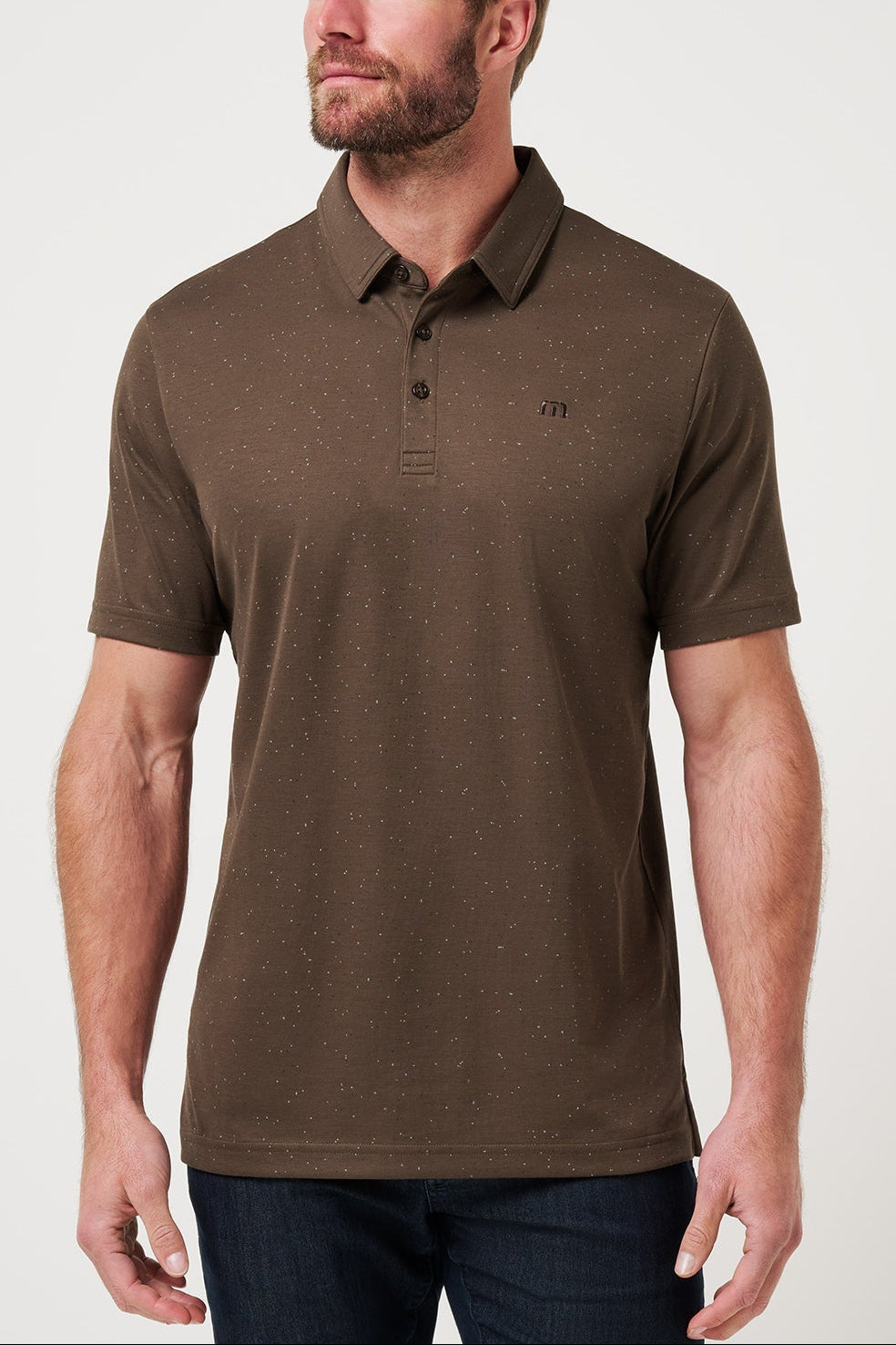 Man wearing a brown polo shirt with a logo on a light gray background