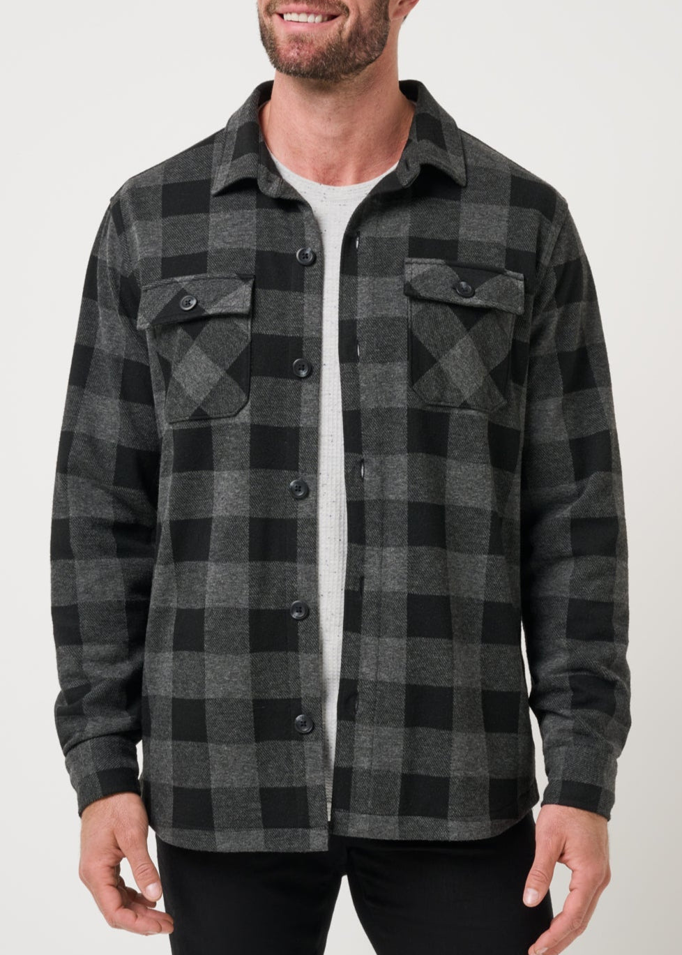 Man wearing a gray and black plaid shirt against a white background