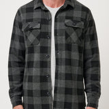Man wearing a gray and black plaid shirt against a white background