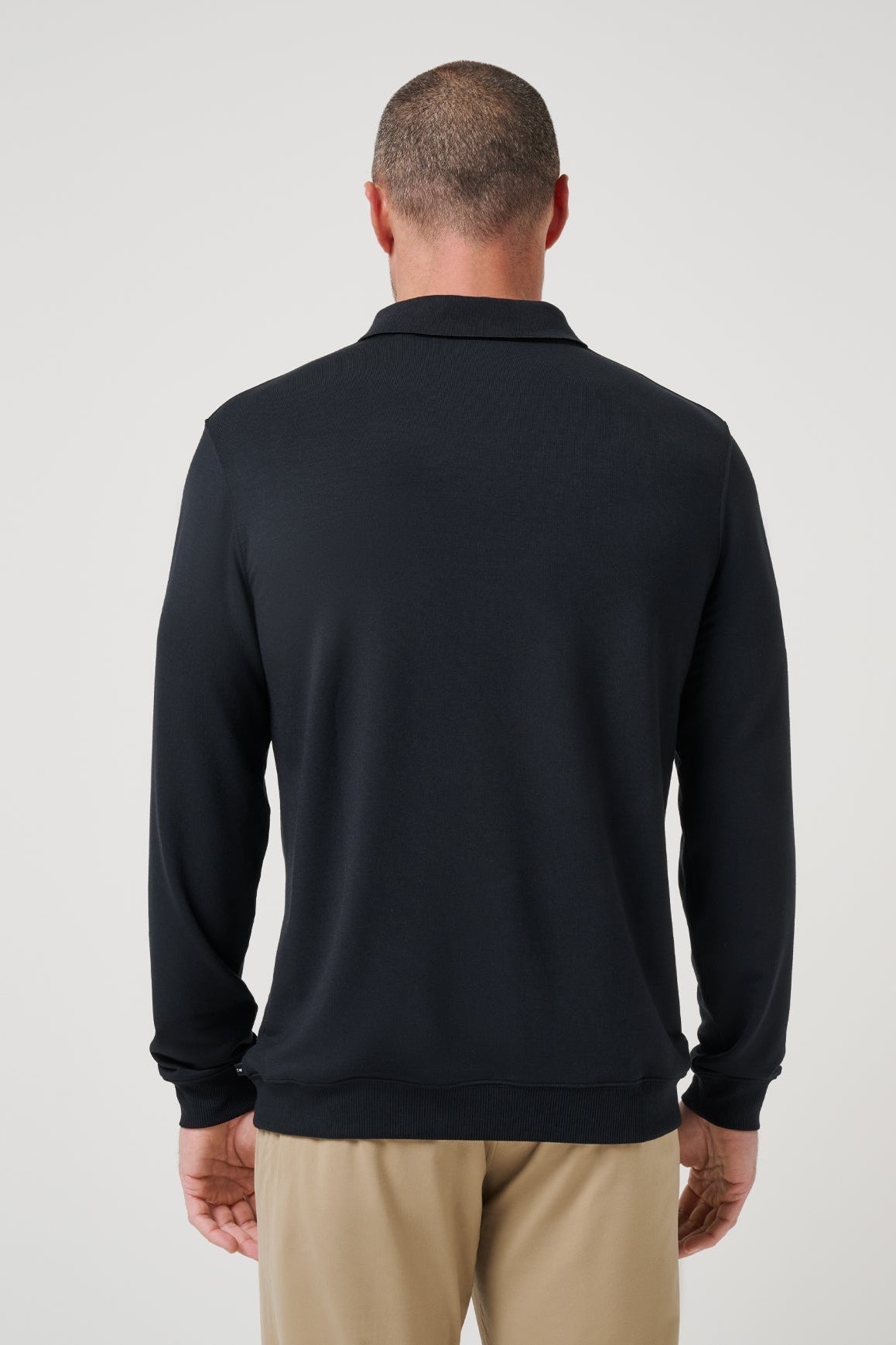 Man wearing a black long-sleeve shirt against a white background