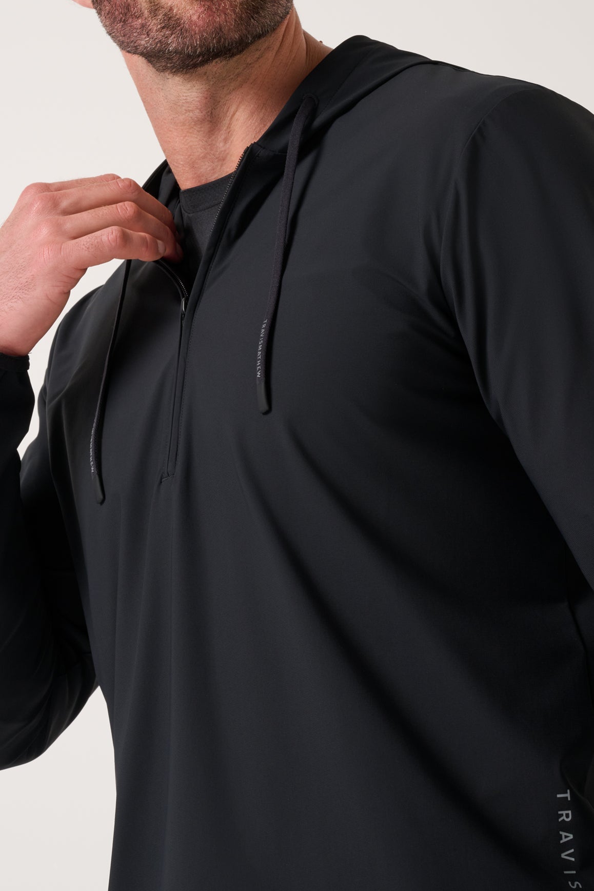 Travis Mathew Hero Hour Tech Hoodie in Black, worn