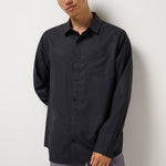 Model wearing the Black Techwoven Cross Check Button-Up with gray pants