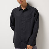 Model wearing the Black Techwoven Cross Check Button-Up with gray pants