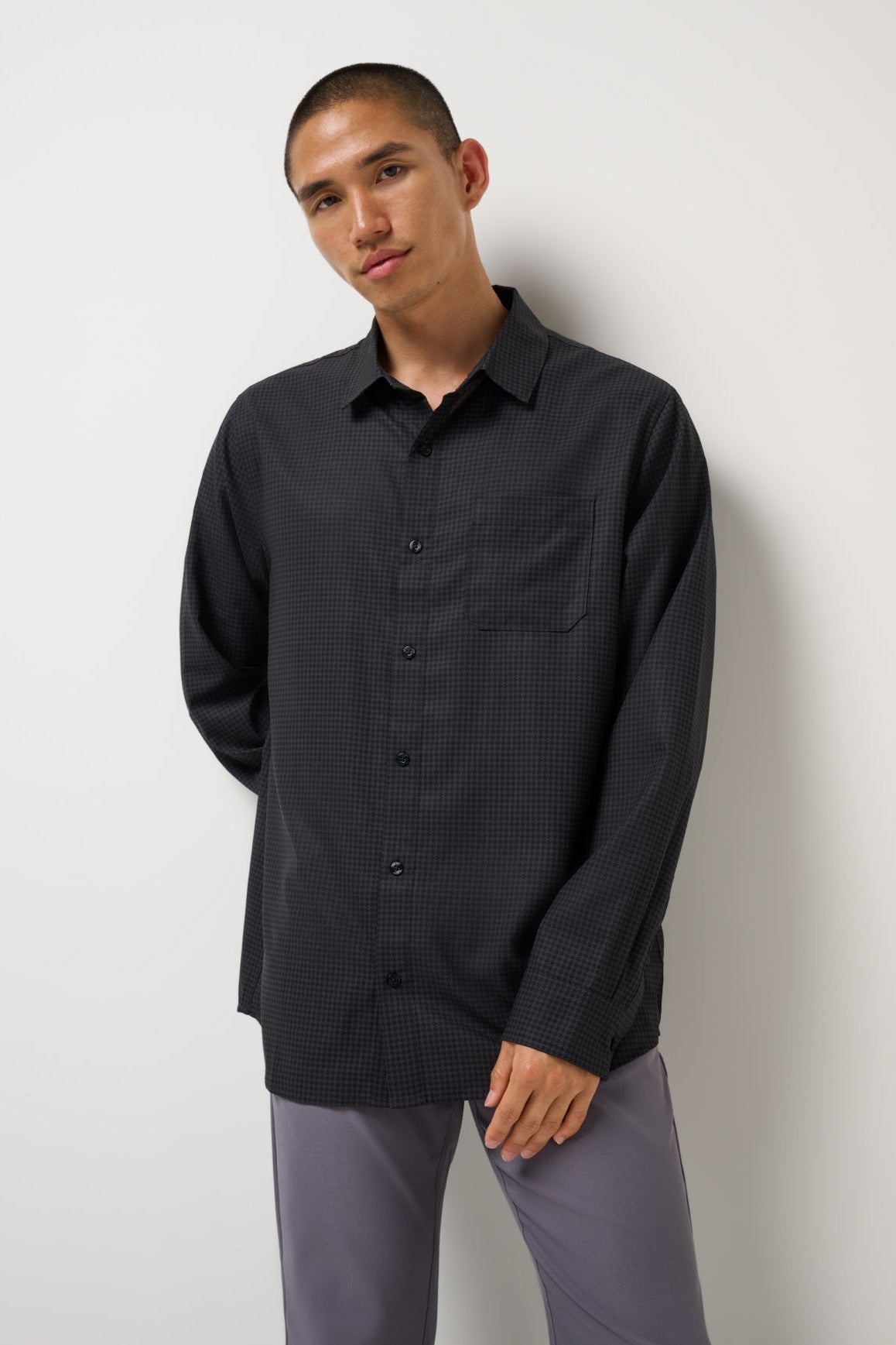 Model wearing the Black Techwoven Cross Check Button-Up with gray pants