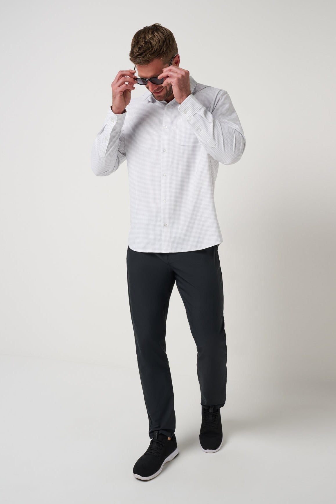 Model wearing the White Techwoven Cross Check Button-Up with dark pants
